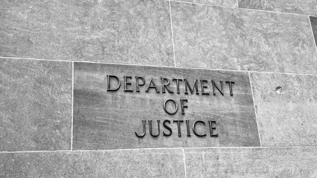 The Department of Justice name carved into the stone of its Washington DC headquarters