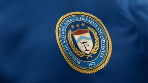 The Bureau of Alcohol, Tobacco, Firearms and Explosives seal on a blue flag