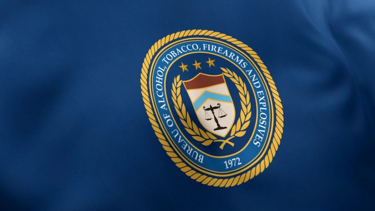 The Bureau of Alcohol, Tobacco, Firearms and Explosives seal on a blue flag