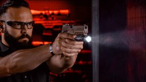 Shooter on an indoor range with a Streamlight weapon light fitted to his pistol