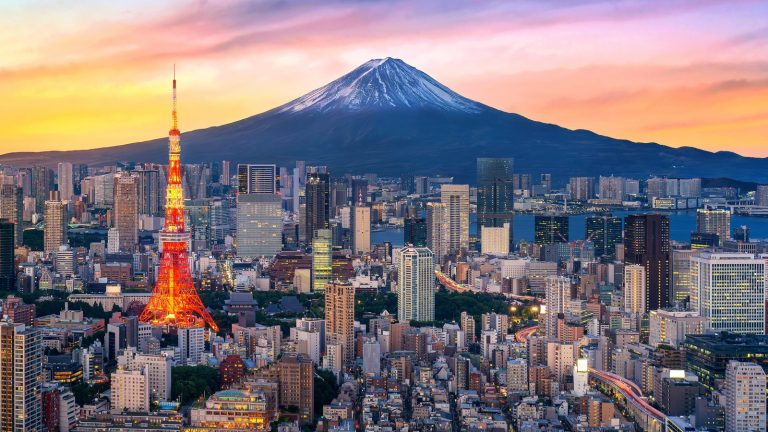 Tokyo skyline at dusk with Tokyo Tower lit up and Mount Fuji behind