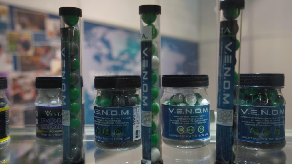 Tubes and jars of V.E.N.O.M. less-lethal irritant projectiles on a display stand